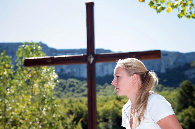 French far-right party Front National (FN) MP Marion Marechal-Le Pen stands in front of a cross as she leaves after taking part in a debate at the Sainte Baume Catholic summer congress on August 29, 2015 in Plan-d'Aups-Sainte-Baume, southern France. AFP PHOTO / BERTRAND LANGLOIS